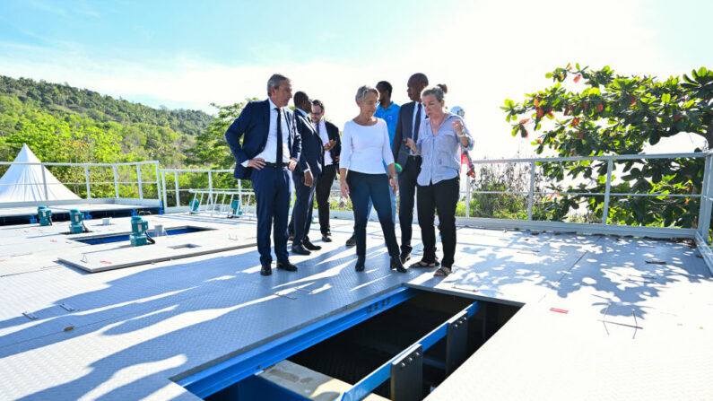 La Première ministre Élisabeth Borne (au c.), flanquée du ministre des Outre-mer Philippe Vigier (à g.), en visite d'une usine de dessalement d'eau de mer à Dzaoudzi, sur l'île de Mayotte, le 8 décembre 2023. (Photo MIGUEL MEDINA/AFP via Getty Images)