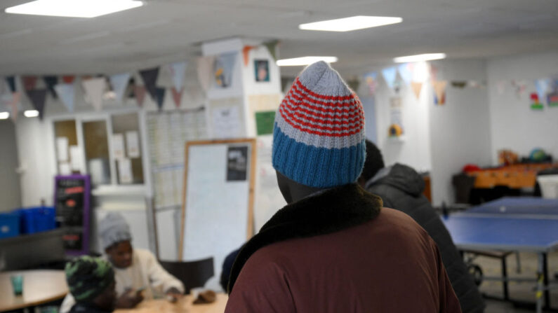 Un migrant regarde des hommes jouant aux dominos aux "terrasses solidaires", un refuge de solidarité pour les migrants qui ont traversé les Alpes, à Briançon, le 8 décembre 2023. (Photo: NICOLAS TUCAT/AFP via Getty Images)