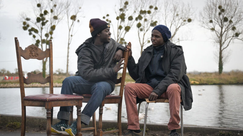 Des migrants soudanais discutent dans un camp de migrants, à Ouistreham, le 11 décembre 2023. (Photo LOU BENOIST/AFP via Getty Images)