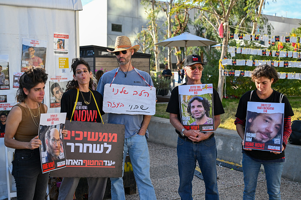 Des parents et des sympathisants des otages israéliens tiennent leurs portraits lors d'une manifestation appelant à leur libération, devant le musée d'art de Tel-Aviv, le 16 décembre 2023. (Photo ALBERTO PIZZOLI/AFP via Getty Images)