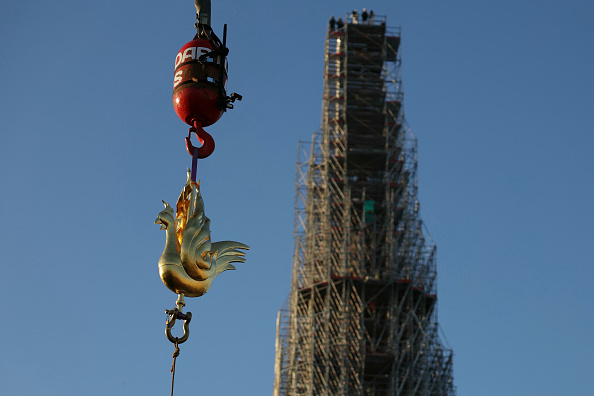 Le nouveau coq doré est soulevé par une grue pour être installé au sommet de la flèche de la cathédrale Notre-Dame, le 16 décembre 2023. (Photo THOMAS SAMSON/AFP via Getty Images)