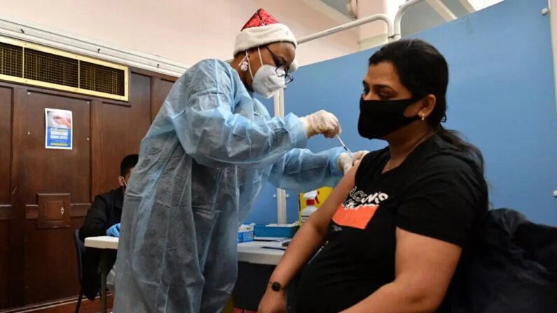 Un agent de santé administre une dose du vaccin contre le Covid-19 à une femme enceinte dans un centre de vaccination mobile à la mairie de Redbridge, à l'est de Londres, le 25 décembre 2021. (Justin Tallis/AFP via Getty Images)