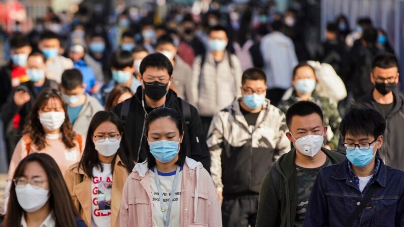 Des banlieusards portent des masques de protection alors qu'ils sortent d'une rame dans une station de métro à l'heure de pointe le lundi 13 avril 2020 à Pékin, en Chine. (Lintao Zhang/Getty Images)