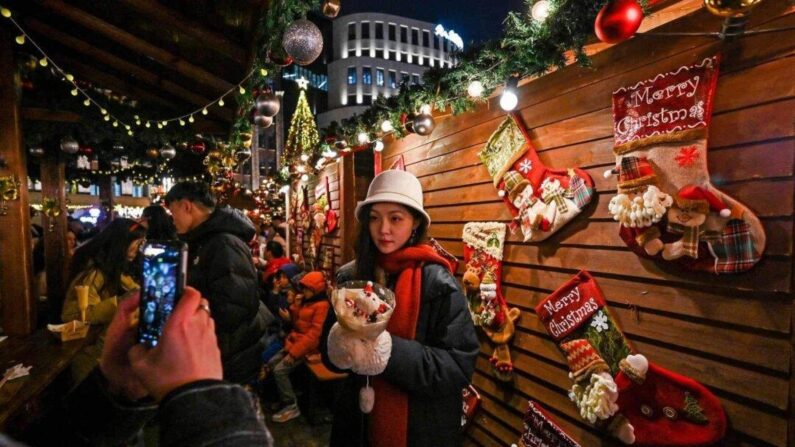 Des personnes visitent un marché de Noël dans le district de Huangpu à Shanghai le 23 décembre 2023. (Hector Retamal / AFP via Getty Images)