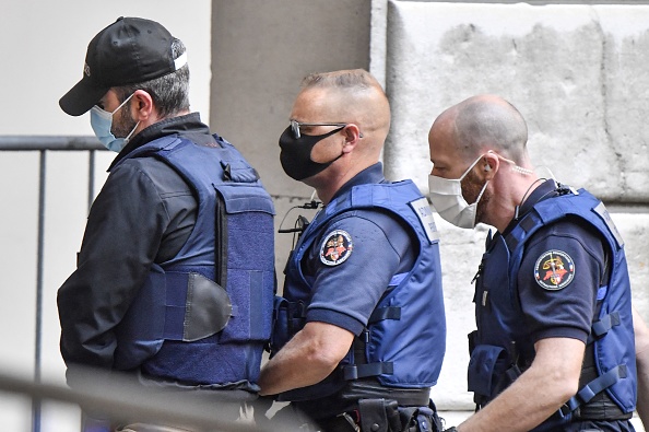 Nordahl Lelandais (à g.) escorté par des agents de l'administration pénitentiaire, arrive au palais de justice de la ville de Chambéry, le 4 mai 2021. (Photo PHILIPPE DESMAZES/AFP via Getty Images)