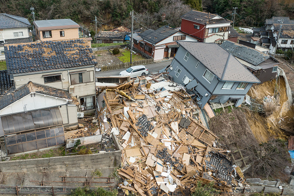 Des maisons endommagées, dont une totalement effondrée (au c.), dans une rue de Wajima, préfecture d'Ishikawa, le 2 janvier 2024. (Photo FRED MERY/AFP via Getty Images)