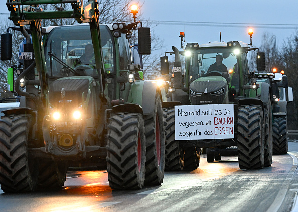 Un agriculteur affichant sur son tracteur le slogan : « Il ne faut jamais oublier que ce sont nous les agriculteurs qui produisons la nourriture », lors d'une manifestation contre la politique agricole du gouvernement d'Olaf Scholz. (Photo THOMAS KIENZLE/AFP via Getty Images)