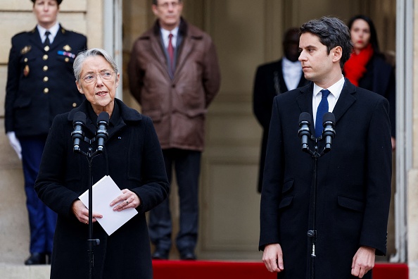 La Première ministre sortante Élisabeth Borne prononce un discours à côté du nouveau Premier ministre Gabriel Attal lors de la cérémonie de passation de pouvoirs à l'Hôtel Matignon à Paris, le 9 janvier 2024. (Photo LUDOVIC MARIN/POOL/AFP via Getty Images)