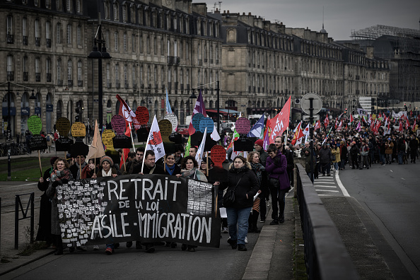 Des manifestants tiennent une banderole sur laquelle on peut lire "retrait de la loi asile-immigration" lors d'un rassemblement contre la nouvelle loi française sur l'immigration, à Bordeaux, le 14 janvier 2024. (Photo PHILIPPE LOPEZ/AFP via Getty Images)