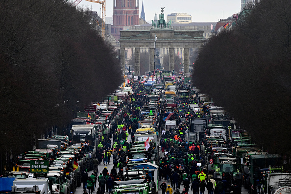 Des tracteurs et des camions se tiennent devant la Porte de Brandebourg, emblème de Berlin, lors d'une manifestation d'agriculteurs et de chauffeurs routiers, le 15 janvier 2024 à Berlin. (Photo : JOHN MACDOUGALL/AFP via Getty Images)