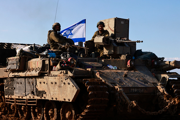 Des soldats israéliens dans un convoi de véhicules blindés revenant du territoire palestinien. (Photo MENAHEM KAHANA/AFP via Getty Images)