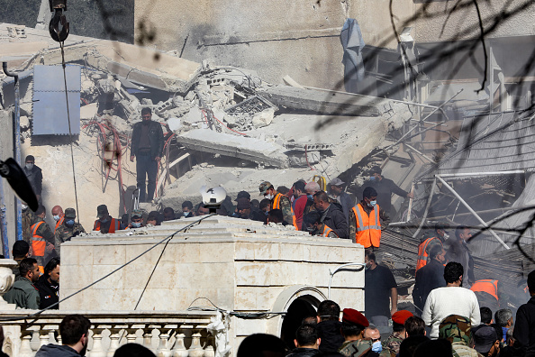 Des personnes et des sauveteurs se rassemblent devant un bâtiment détruit lors d'une frappe israélienne à Damas, le 20 janvier 2024. (Photo LOUAI BESHARA/AFP via Getty Images)