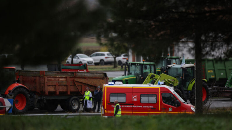Des sauveteurs se tiennent près d'un véhicule de pompiers, garé près de l'endroit où une agricultrice a été tuée et où son mari et sa fille adolescente ont été gravement blessés le 23 janvier 2024, à Pamiers, dans l'Ariège. (Photo: VALENTINE CHAPUIS/AFP via Getty Images)