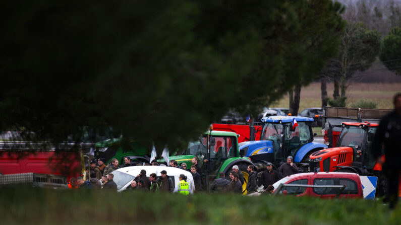 Des manifestants se tiennent près de tracteurs, garés près de l'endroit où une agricultrice et sa fille ont été tuées, le 23 janvier 2024. (Photo: VALENTINE CHAPUIS/AFP via Getty Images)