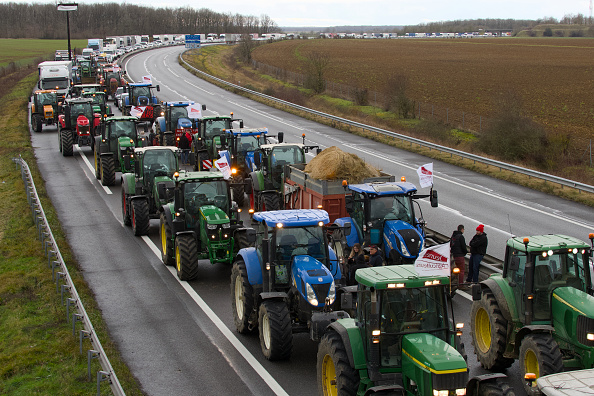 Des agriculteurs conduisent leurs tracteurs pour perturber la circulation sur l'autoroute A71, à Levet près de Bourges, le 24 janvier 2024. (Photo GUILLAUME SOUVANT/AFP via Getty Images)