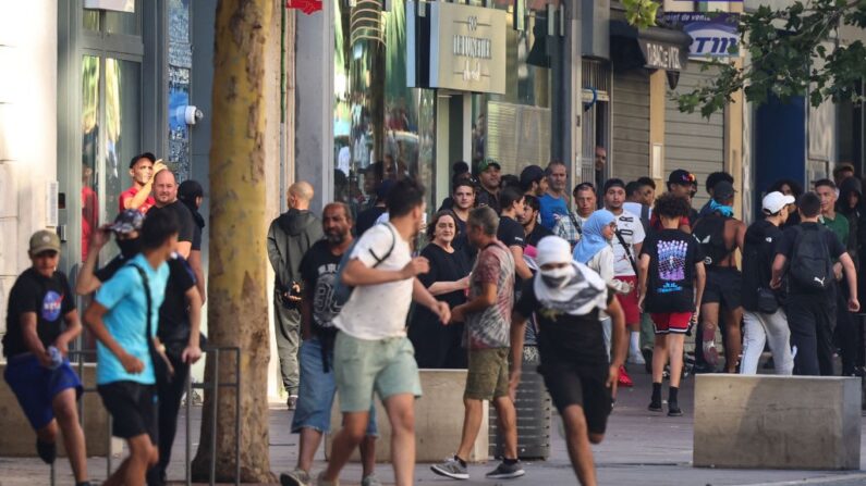 Des manifestants courent lors d'une manifestation contre la police à Marseille le 1er juillet 2023, après une quatrième nuit consécutive d'émeutes en France à la suite du décès du jeune Nahel tué par la police. (Photo by CLEMENT MAHOUDEAU / AFP)