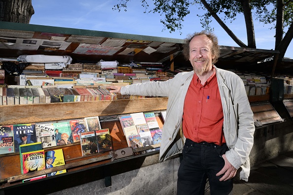 Jérôme Callais, bouquiniste et président de l'association culturelle des libraires d'occasion, pose devant son stand de vente de livres anciens et de vieilles affiches, sur la Seine à Paris. (Photo MIGUEL MEDINA/AFP via Getty Images)