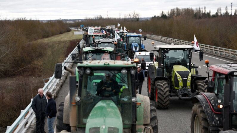 Les agriculteurs français stoppent leurs tracteurs sur l'autoroute A16 près de L'Isle-Adam, le 30 janvier 2024, alors que les agriculteurs français maintiennent des barrages routiers sur les principales autoroutes menant à Paris pour la deuxième journée. (Crédit photo Sameer Al-Doumy / AFP)