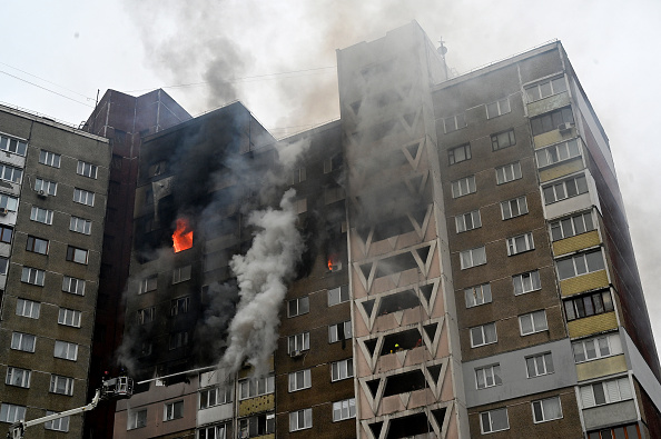 Des sauveteurs éteignent le feu dans un bâtiment en flammes à la suite d'une attaque de missiles à Kiev, le 7 février 2024. (Photo SERGEI SUPINSKY/AFP via Getty Images)
