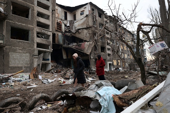 Des habitants passent devant un immeuble détruit par une attaque de missiles russes dans la ville de Selydove, en Ukraine. (Photo ANATOLII STEPANOV/AFP via Getty Images)
