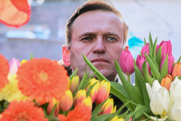 Des fleurs sont placées autour du portrait du leader de l'opposition russe Alexeï Navalny décédé, dans un mémorial improvisé devant l'ancien consulat russe à Francfort-sur-le-Main en Allemagne, le 20 février 2024. (Photo AFP via Getty Images)