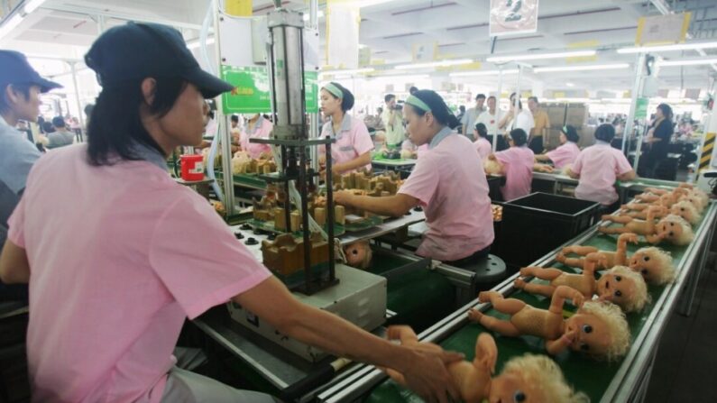 Photo d'archives montrant des ouvriers assemblant des poupées sur une chaîne de production à Guangdong, en Chine, le 4 septembre 2007 (Feng Li/Getty Images)