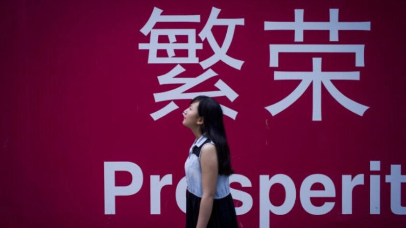 Une femme devant un panneau avec les caractères pour "prospérité" en chinois à Pékin le 28 juillet 2015. (Fred Dufour/AFP/Getty Images)