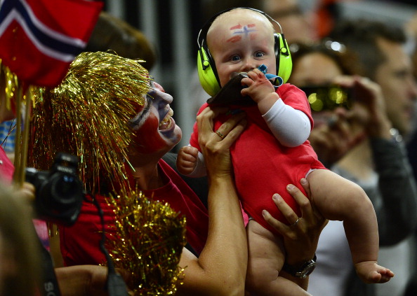 Une fan de handball norvégien tient un bébé portant des protections auditives pendant le match de handball pour les Jeux Olympiques de Londres 2012. (Photo JAVIER SORIANO/AFP/GettyImages)