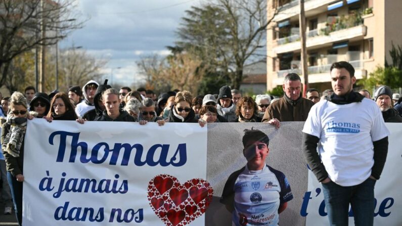 Le 22 novembre 2023, à Romans-sur-Isère, des personnes défilent derrière une banderole sur laquelle on peut lire "Thomas, dans nos cœurs à jamais, on t'aime". (Photo: OLIVIER CHASSIGNOLE/AFP via Getty Images)