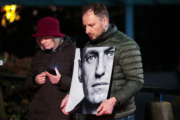 Un homme tient une photo du leader de l'opposition russe Alexeï Navalny à Seattle aux États-Unis le 1er mars 2024. (Photo JASON REDMOND/AFP via Getty Images)