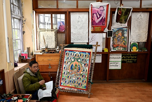 Lobsang Tenzin, professeur d'art, se reposant à côté d'une « Thangka », une peinture bouddhiste tibétaine traditionnelle, à l'institut Norbulingka, à Dharamsala le 20 février 2024. (Photo SAJJAD HUSSAIN/AFP via Getty Images)