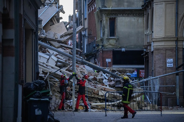 Des pompiers interviennent sur le site d'un immeuble effondré dans le centre de Toulouse, le 9 mars 2024. (Photo ED JONES/AFP via Getty Images)