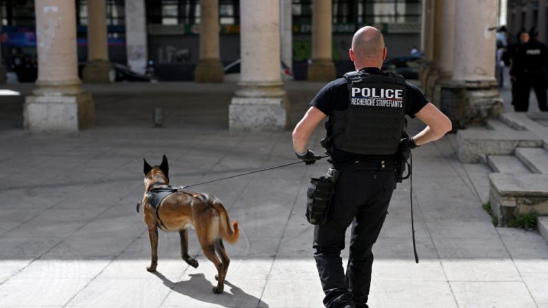 Un policier et son chien spécialisé patrouillent dans le centre-ville de Marseille, dans le sud de la France, le 21 mars 2024 (NICOLAS TUCAT/AFP via Getty Images)