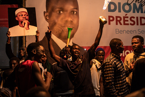 Les partisans de Bassirou Diomaye Faye, candidat de l'opposition à l'élection présidentielle, et d'Ousmane Sonko, chef de file de l'opposition, célèbrent le dépouillement des votes au siège de la coalition de M. Diomaye, à Dakar, le 24 mars 2024. (Photo JOHN WESSELS/AFP via Getty Images)