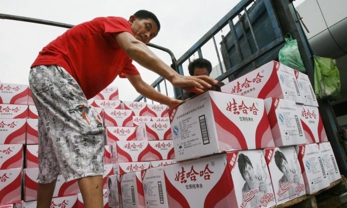 Des ouvriers chinois chargent des bouteilles d'eau potable Wahaha dans un camion en vue de leur expédition. (Mark Ralston/AFP/Getty Images)