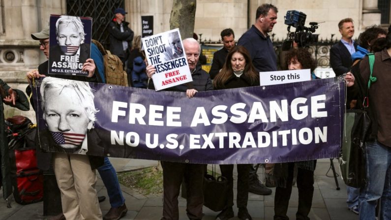 Des partisans de Julian Assange, fondateur de WikiLeaks, tiennent une banderole et des pancartes devant la Royal Courts of Justice, la Haute Cour de justice britannique, dans le centre de Londres, le 26 mars 2024. (Daniel Leal/AFP via Getty Images)