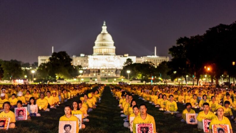 Des pratiquants du Falun Gong participent à une veillée aux chandelles à la mémoire des pratiquants du Falun Gong décédés à la suite des persécutions menées par le Parti communiste chinois depuis 24 ans, sur le National Mall de Washington, le 20 juillet 2023. (Samira Bouaou/The Epoch Times)