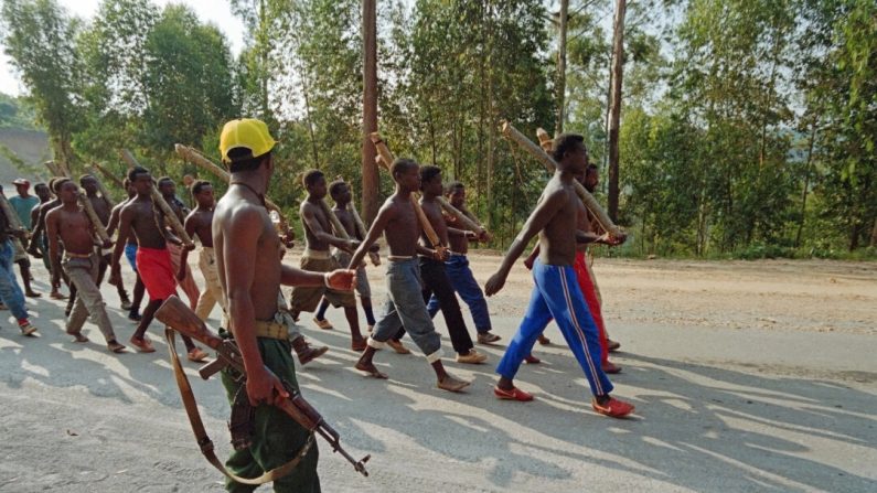Un groupe de jeunes miliciens hutus s'entraîne avec des bâtons sur une route près de Mushubati, au Rwanda, le 12 juin 1994. (Alexander Joe/AFP via Getty Images)