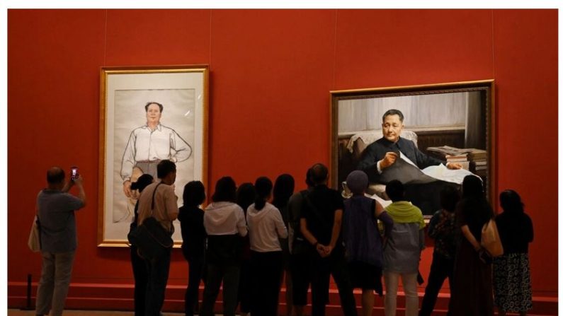 Des visiteurs regardent les portraits des dirigeants communistes Mao Zedong (à g.) et Deng Xiaoping lors d'une exposition d'art célébrant le 100e anniversaire de la fondation du Parti communiste chinois à Pékin, le 24 juin 2021. (Greg Baker/AFP via Getty Images)