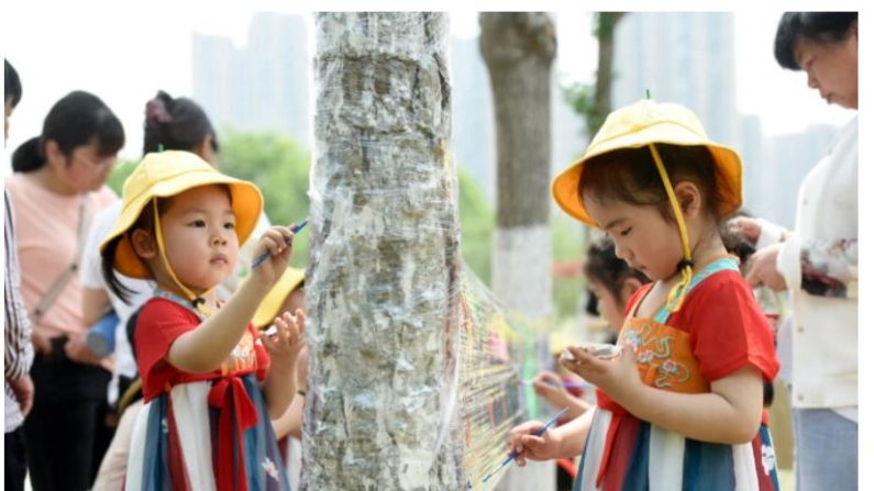 Des enfants peignent sur une bâche en plastique dans un parc à l'occasion de la Journée internationale de l'enfance à Haian, dans la province chinoise du Jiangsu, le 1er juin 2022. (STR/AFP via Getty Images)