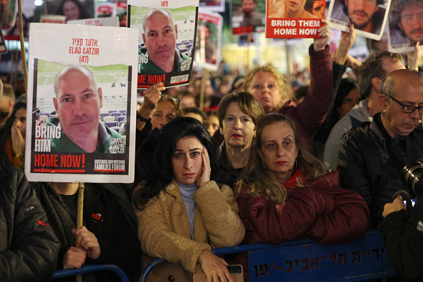 Des manifestants soulèvent des portraits d'Elad Katzir, appelant à leur libération à Tel Aviv, le 3 février 2024. (Photo AHMAD GHARABLI/AFP via Getty Images)