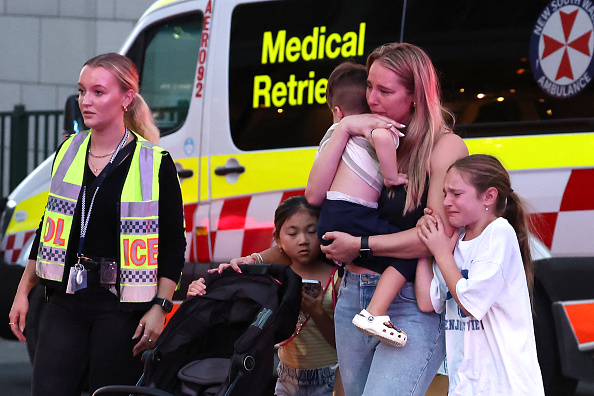 Des familles sortent du centre commercial Westfield Bondi Junction après une agression à l'arme blanche à Sydney, le 13 avril 2024. (Photo DAVID GRAY/AFP via Getty Images)