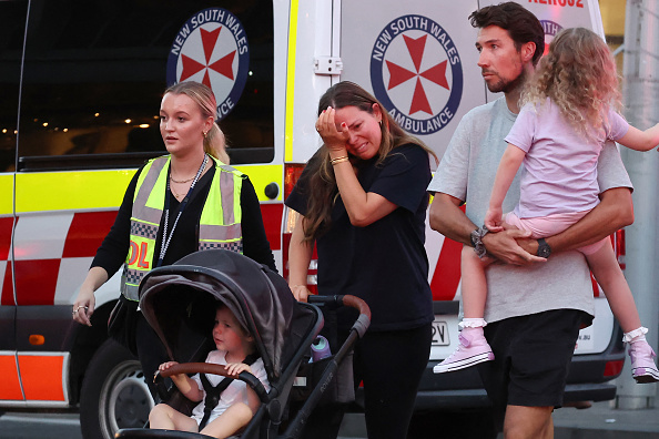 Des familles sortent du centre commercial Westfield Bondi Junction après l’attaque au couteau à Sydney le 13 avril 2024. (Photo DAVID GRAY/AFP via Getty Images)