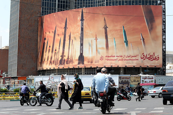 Des automobilistes passent devant un panneau d'affichage représentant des missiles iraniens à Téhéran. (Photo ATTA KENARE/AFP via Getty Images)