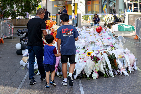 Des personnes déposent des fleurs devant le centre commercial Westfield en hommage aux victimes le 16 avril 2024 à Bondi Junction, Australie. (Photo Brendon Thorne/Getty Images)
