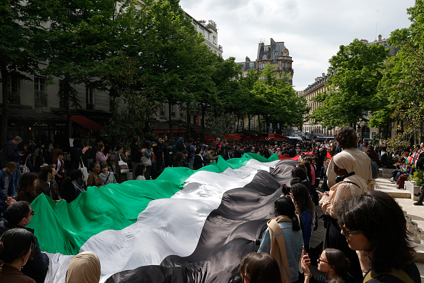 Des étudiants arborent un drapeau palestinien géant alors qu'ils participent à un rassemblement de soutien aux Palestiniens à l'université de la Sorbonne, à Paris le 29 avril 2024. (Photo GEOFFROY VAN DER HASSELT/AFP via Getty Images)