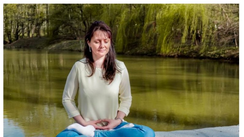 Natalya Minenkova pratique la méditation dans le parc Dendropark à Moscou, Russie, le 5 juillet 2022. (Epoch Times)