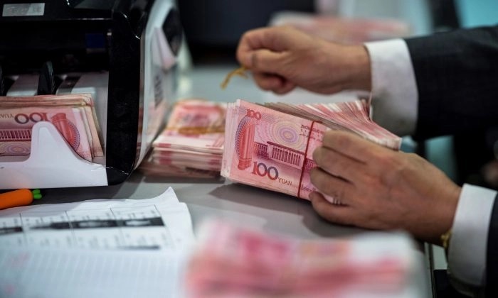 Un employé de banque compte les billets de 100 yuans dans une banque à Shanghai le 8 août 2018. (Johannes Eisele/AFP/Getty Images)