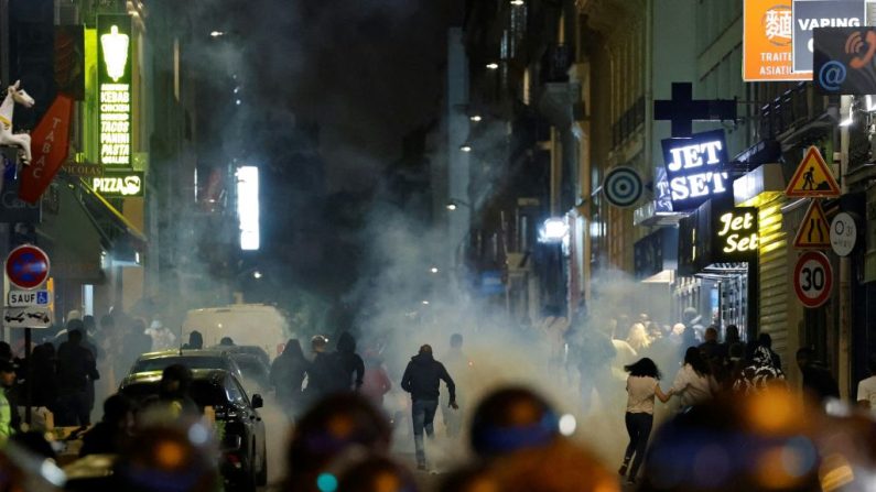 Des émeutiers courent alors que des policiers utilisent des gaz lacrymogènes à Paris, le 2 juillet 2023. (Photo: LUDOVIC MARIN/AFP via Getty Images)
