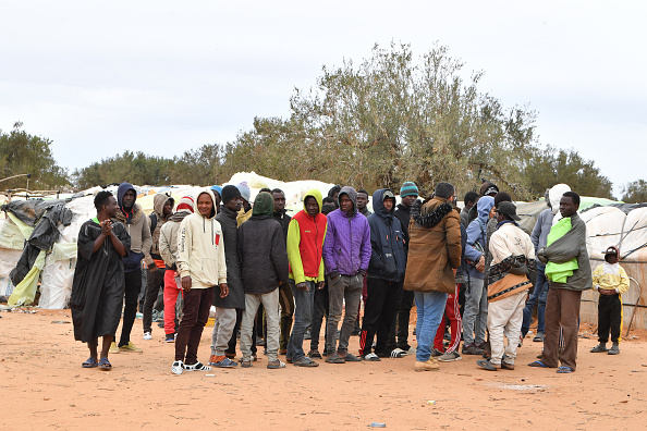 Des migrants d'Afrique subsaharienne rassemblés près de leurs tentes dans un camp à Jebeniana, dans le gouvernorat de Sfax, en Tunisie, le 24 avril 2024. Le président Kais Saied a déclaré dans un discours l'année dernière que des "hordes de migrants illégaux" représentaient une menace démographique pour la Tunisie. (Photo FETHI BELAID/AFP via Getty Images)
